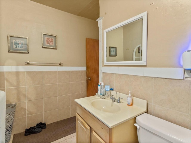 bathroom featuring vanity, tile walls, and toilet