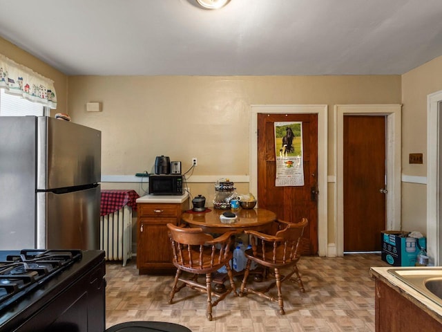 kitchen featuring radiator heating unit and stainless steel refrigerator