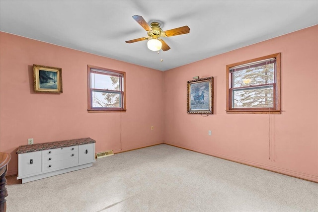 empty room with ceiling fan and light colored carpet