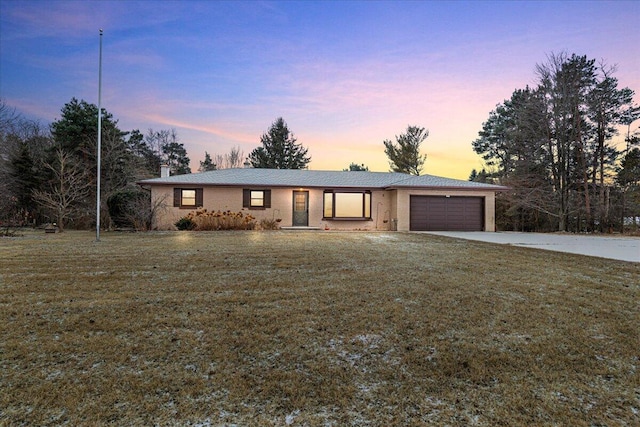 ranch-style home with a yard and a garage