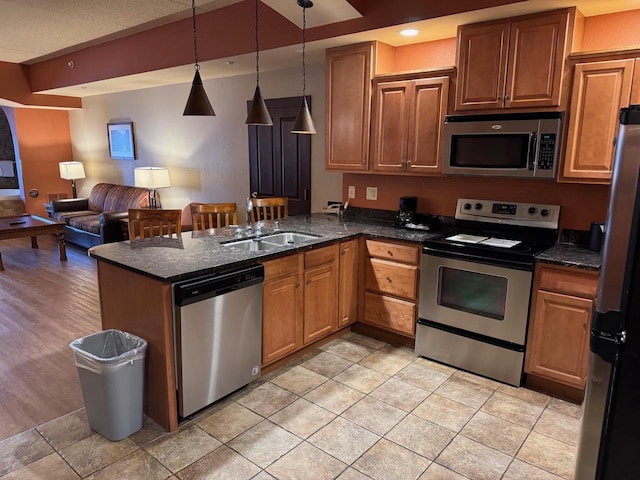 kitchen featuring light tile patterned flooring, sink, kitchen peninsula, pendant lighting, and stainless steel appliances