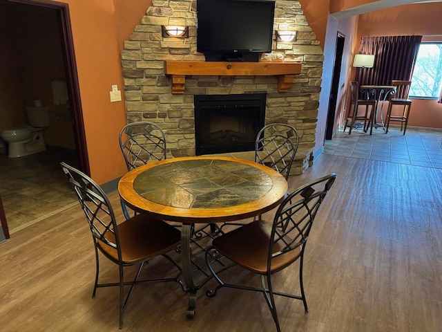 dining area with hardwood / wood-style flooring and a fireplace