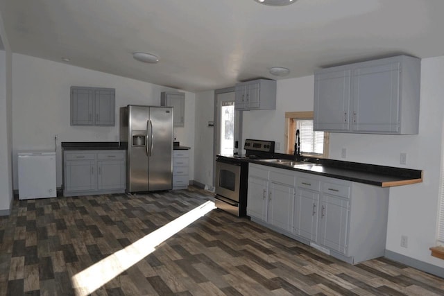 kitchen featuring gray cabinetry, sink, dark hardwood / wood-style floors, and appliances with stainless steel finishes