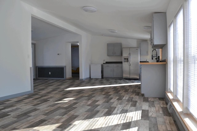 unfurnished living room featuring dark hardwood / wood-style flooring and vaulted ceiling