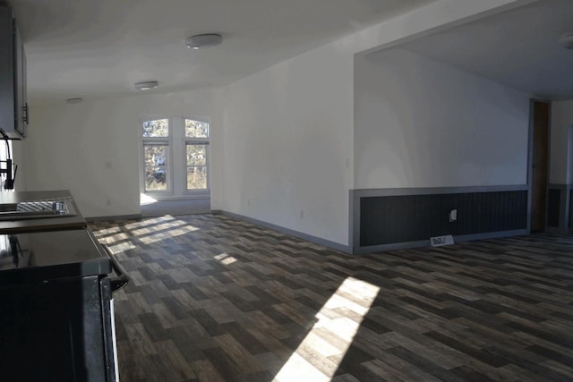 unfurnished living room featuring sink and dark wood-type flooring