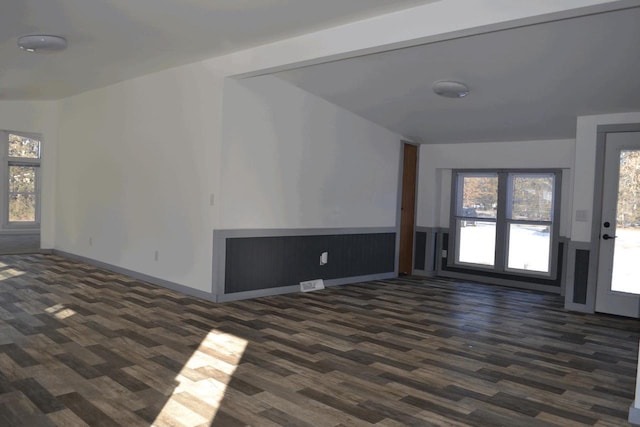 unfurnished living room with plenty of natural light and dark hardwood / wood-style floors