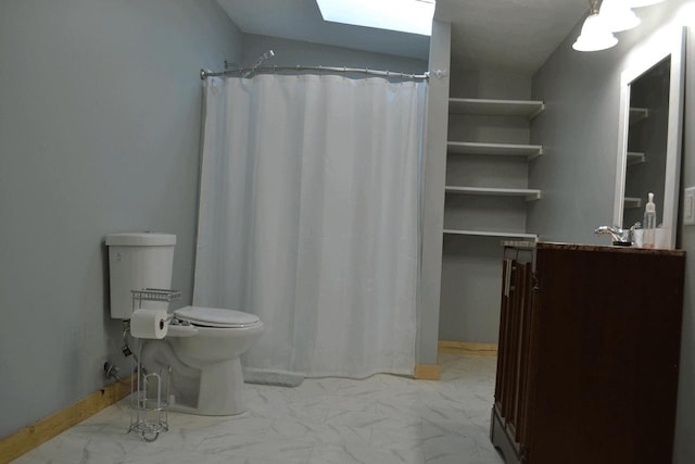 bathroom with a shower with curtain, vanity, a skylight, and toilet