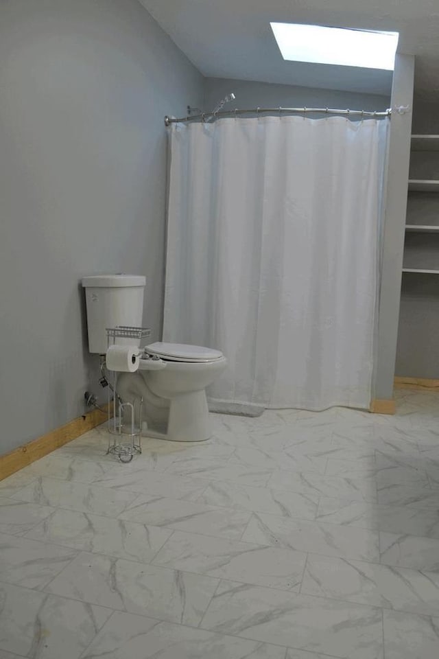 bathroom featuring curtained shower and toilet