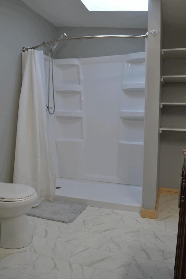 bathroom featuring toilet and curtained shower