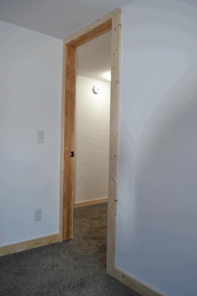 hall with dark colored carpet