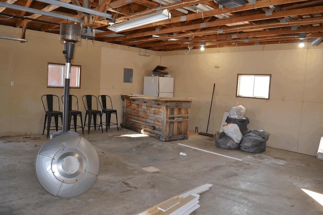 garage with electric panel and white fridge