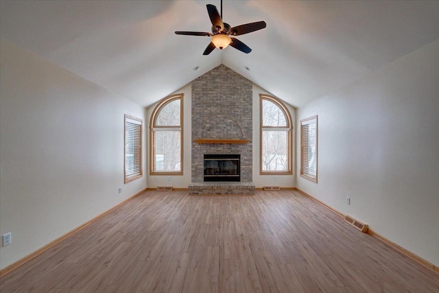 unfurnished living room with a brick fireplace, high vaulted ceiling, ceiling fan, and light wood-type flooring