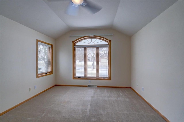 carpeted spare room with vaulted ceiling and ceiling fan