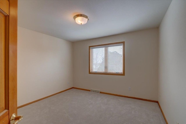 unfurnished room featuring light carpet