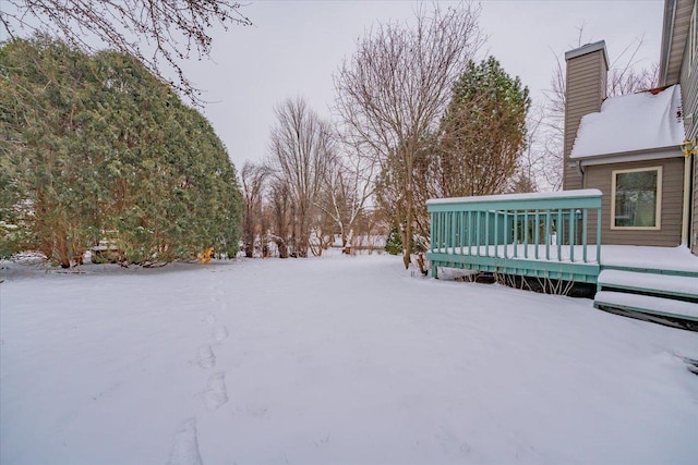 yard covered in snow featuring a deck