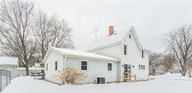 snow covered property featuring central AC unit