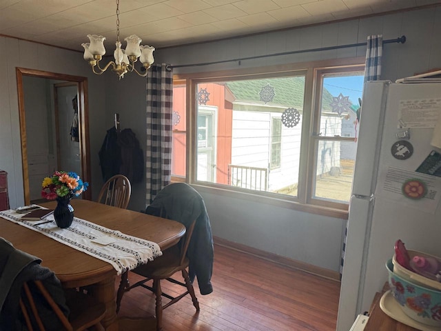 dining area with hardwood / wood-style floors and a chandelier