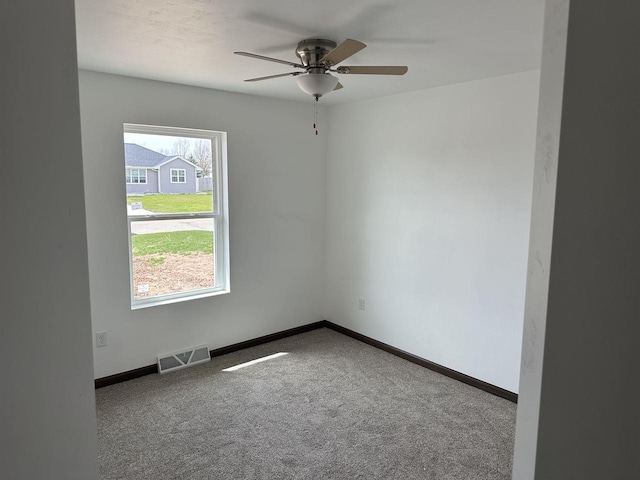 carpeted spare room with ceiling fan