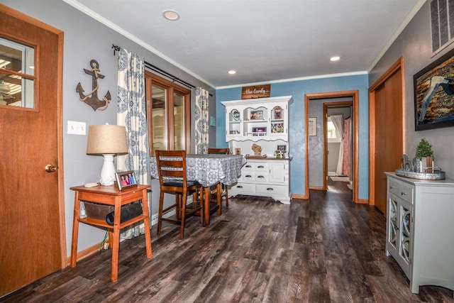 dining area with ornamental molding and dark hardwood / wood-style floors