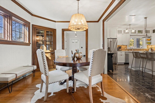 dining room featuring ornamental molding, dark hardwood / wood-style floors, and sink