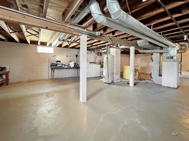 basement with heating unit, separate washer and dryer, and water heater