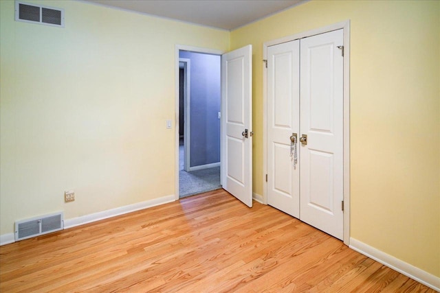 unfurnished bedroom with a closet and light wood-type flooring