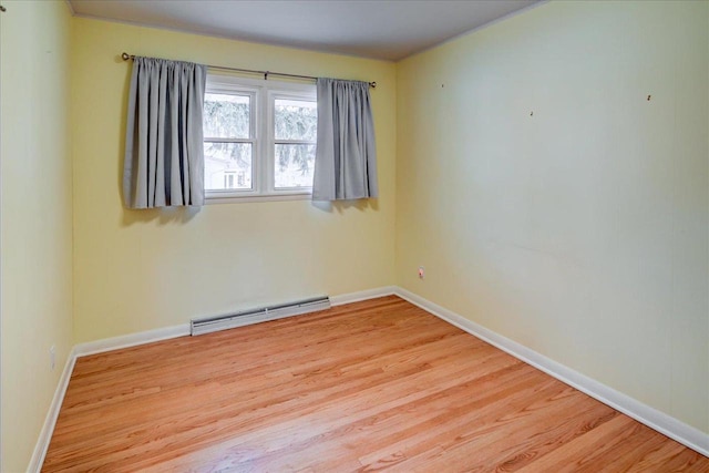 spare room featuring light wood-type flooring and baseboard heating