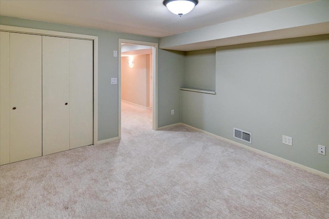 unfurnished bedroom with light colored carpet and a closet