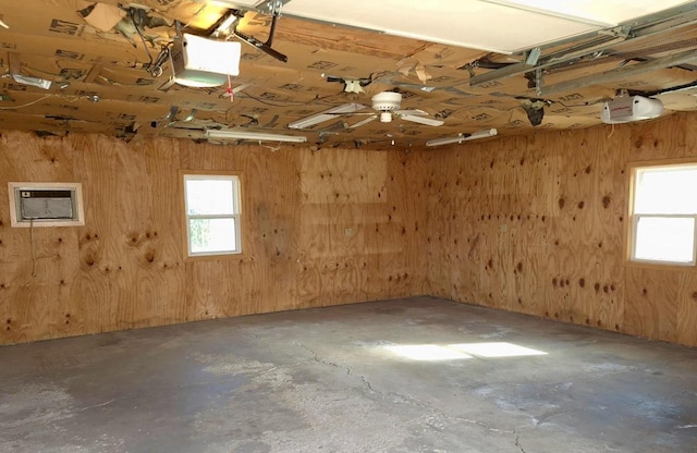 garage with a garage door opener and wood walls