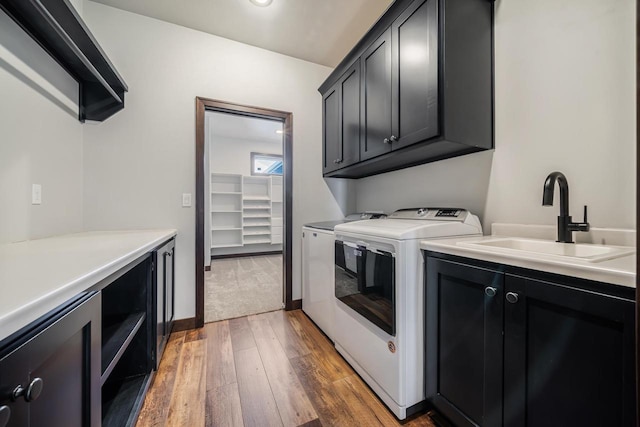 clothes washing area featuring sink, dark wood-type flooring, cabinets, independent washer and dryer, and beverage cooler