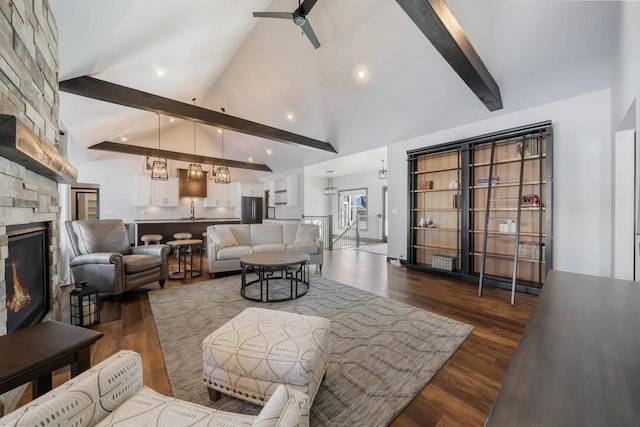 living room with dark wood-type flooring, a stone fireplace, high vaulted ceiling, and beamed ceiling