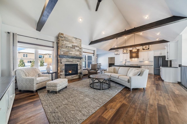 living room with sink, high vaulted ceiling, dark hardwood / wood-style floors, beamed ceiling, and a fireplace