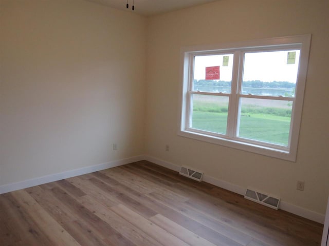 127 Linden Ln, Fox Lake, WI 53933 - unfurnished room featuring light wood finished floors and a water view