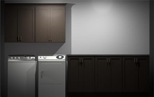 clothes washing area featuring cabinets and separate washer and dryer