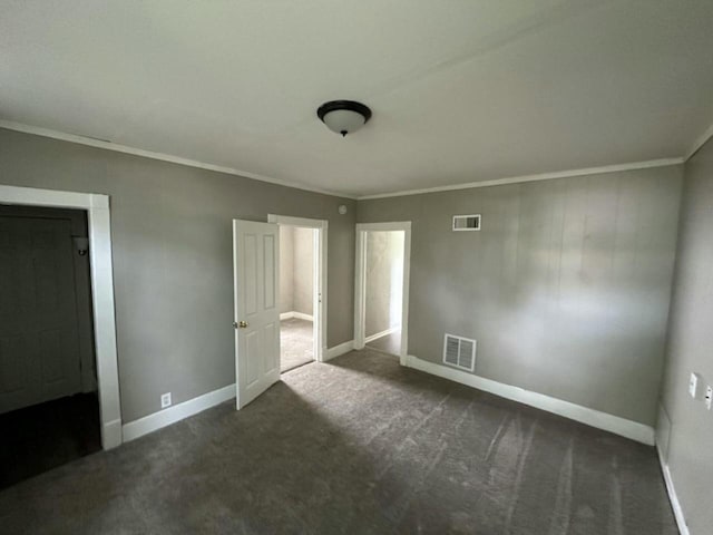 unfurnished bedroom with crown molding and dark carpet