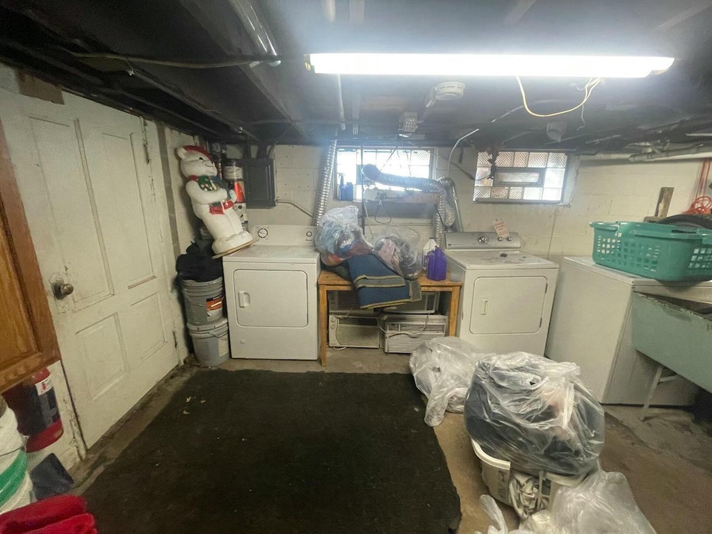 basement with washing machine and dryer, electric panel, and refrigerator