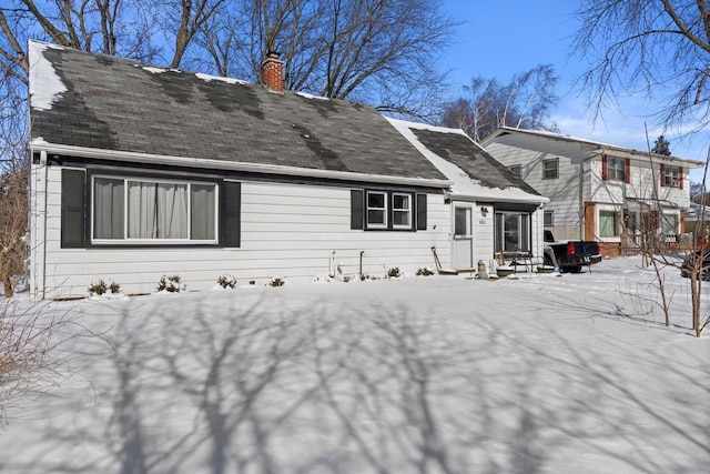 view of snow covered rear of property