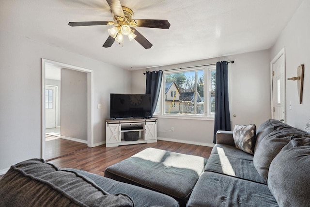 living room featuring dark wood-type flooring and ceiling fan