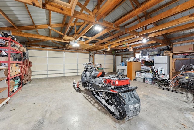 garage featuring white refrigerator and a garage door opener