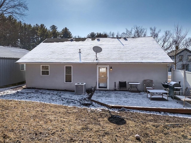 snow covered back of property featuring a deck and central air condition unit