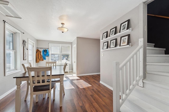 dining area with hardwood / wood-style flooring and a textured ceiling