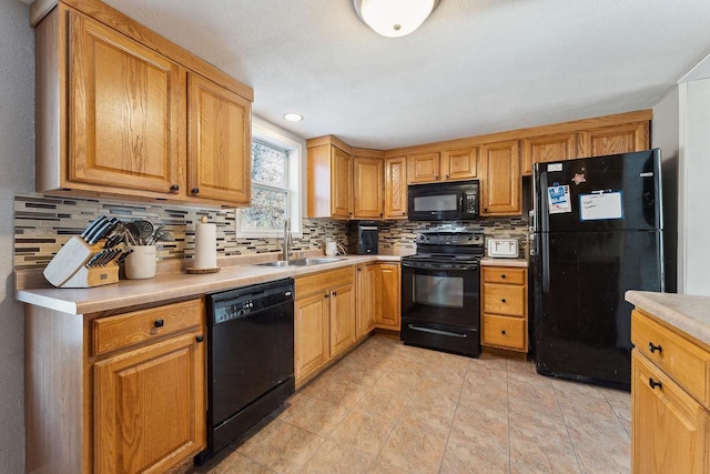 kitchen featuring sink, backsplash, black appliances, and light tile patterned flooring