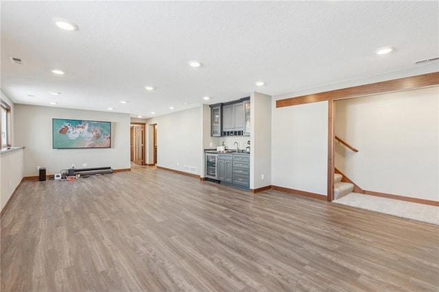 1787 Otter Way, New Richmond, WI 54017 - basement featuring wine cooler, hardwood / wood-style flooring, a textured ceiling, and indoor wet bar