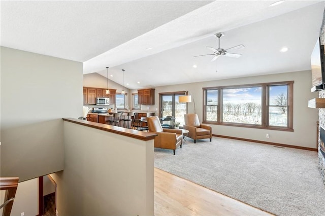 1787 Otter Way, New Richmond, WI 54017 - living room featuring ceiling fan, vaulted ceiling with beams, a fireplace, a textured ceiling, and light wood-type flooring