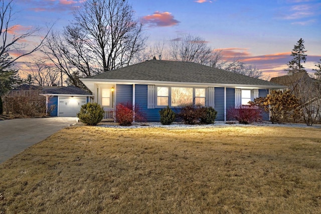 ranch-style house featuring a garage and a yard