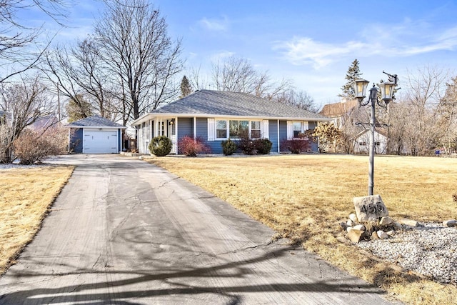 ranch-style home with a garage, an outbuilding, and a front lawn