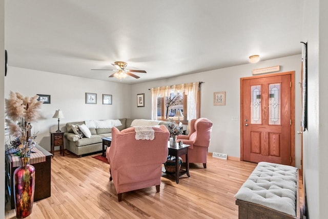 living room with light hardwood / wood-style flooring and ceiling fan