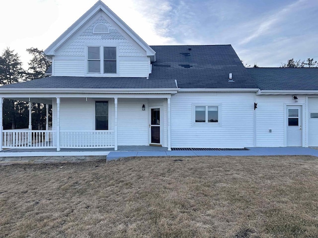 back of house with a porch and a yard