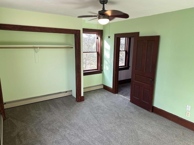 unfurnished bedroom featuring a baseboard heating unit, carpet floors, a closet, and ceiling fan