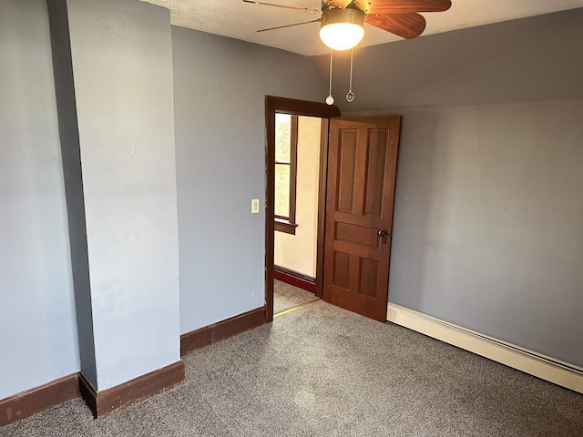 spare room with a baseboard radiator, ceiling fan, and carpet flooring